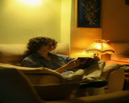 A person peacefully reading a book in a softly lit, quiet corner of a room